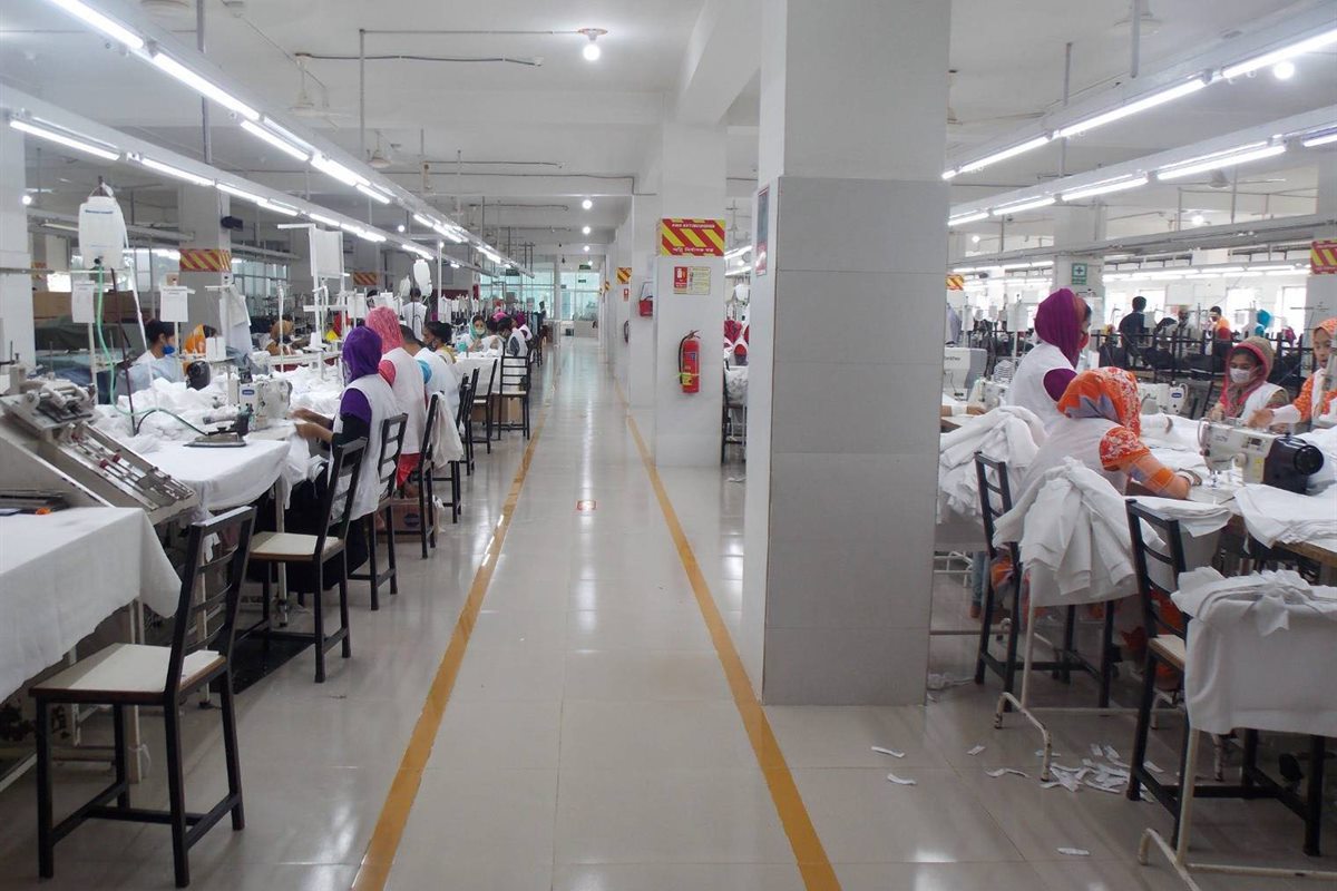 Sewing lines at the Platinum Apparel factory in Ashulia, operators stitching white woven garments