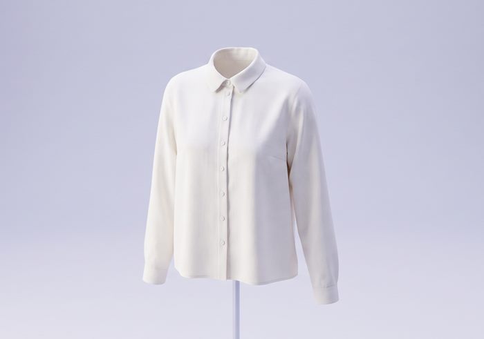 Ivory woven blouse on a stand, showing collar, buttoned placket and set-in sleeves